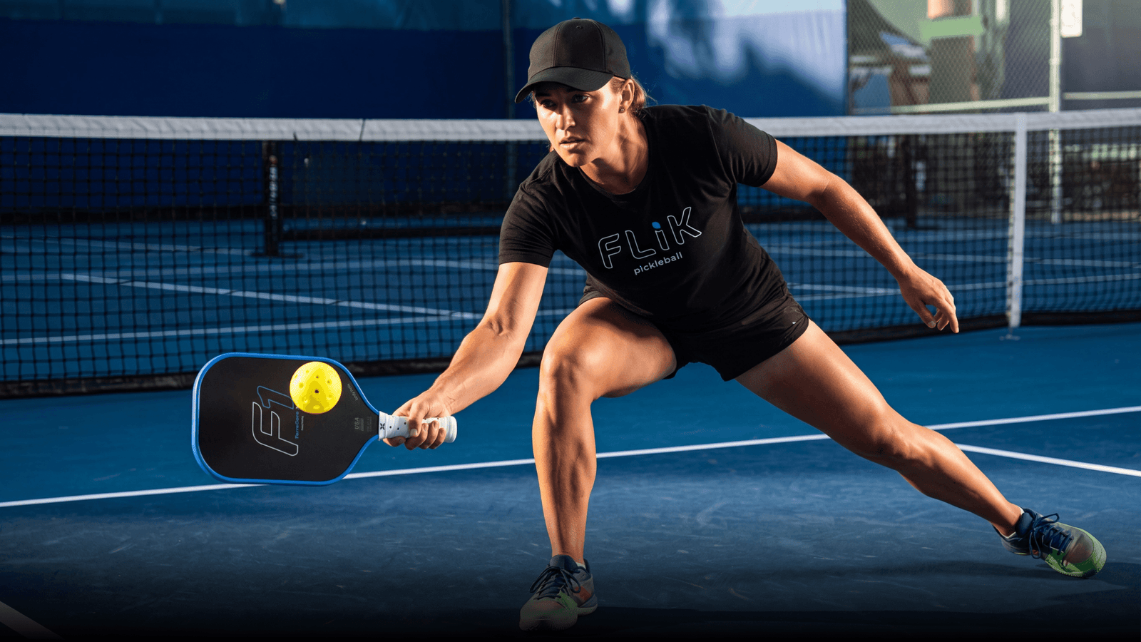 Female pickleball player hitting low forehand
