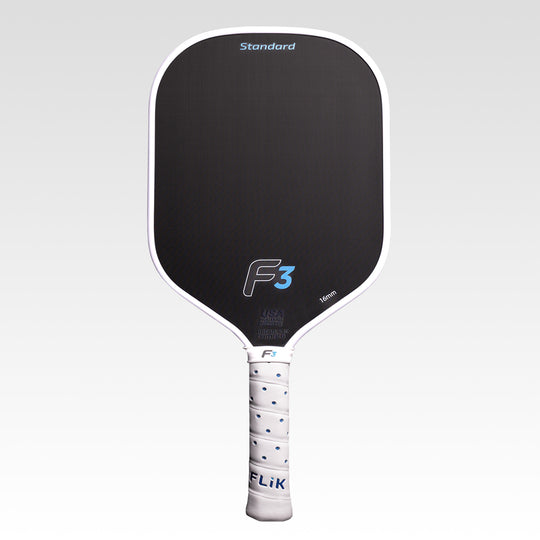 A FLiK pickleball paddle with a black paddle face, white border, white wrapped handle, and blue accents, shown against a light gray gradient background. The paddle features the &